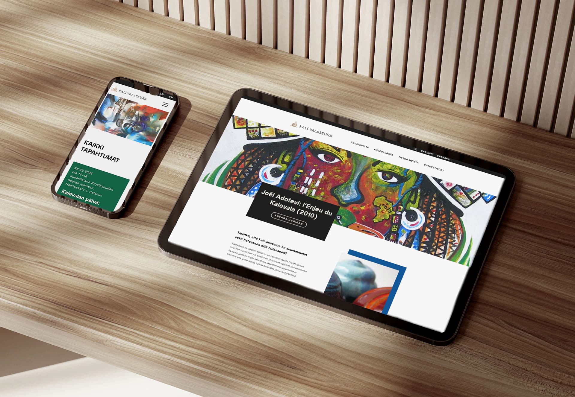 Kuvassa tabletti ja kännykkä, jossa esitetään Kalevalaseuran verkkosivustoa.